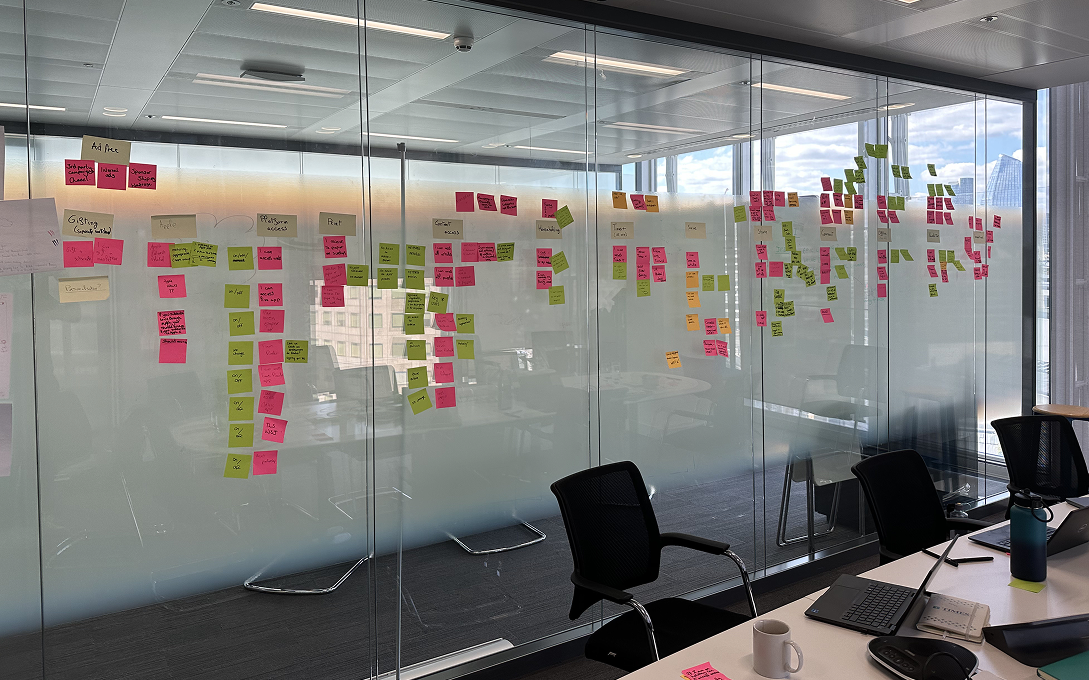 Workshop wall covered in sticky notes mapping subscription features